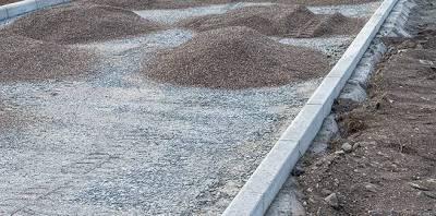 Preparing the gravel base for a new asphalt driveway